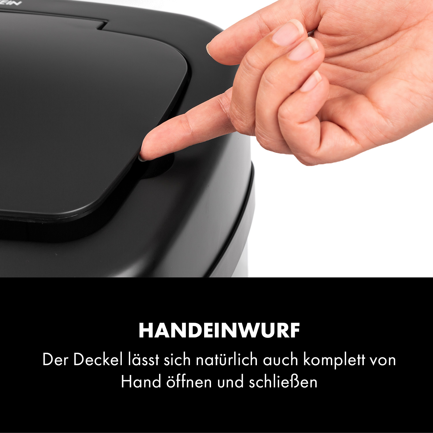 Eine Hand drückt einen Knopf auf einem schwarzen Mülleimerdeckel.