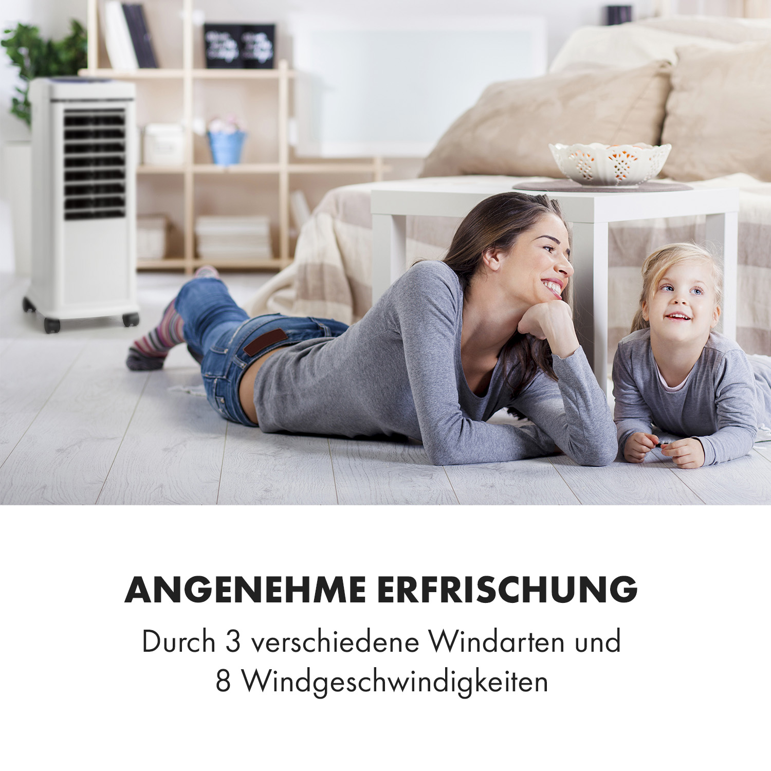 Frau und Mädchen am Boden schauen sich an. Luftkühler im Hintergrund. Text: Angenehme Erfrischung.