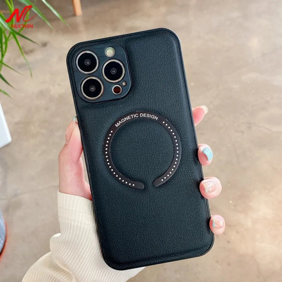Eine schwarze Handyhülle mit Magnetring. Das Telefon wird von einer Hand gehalten.
