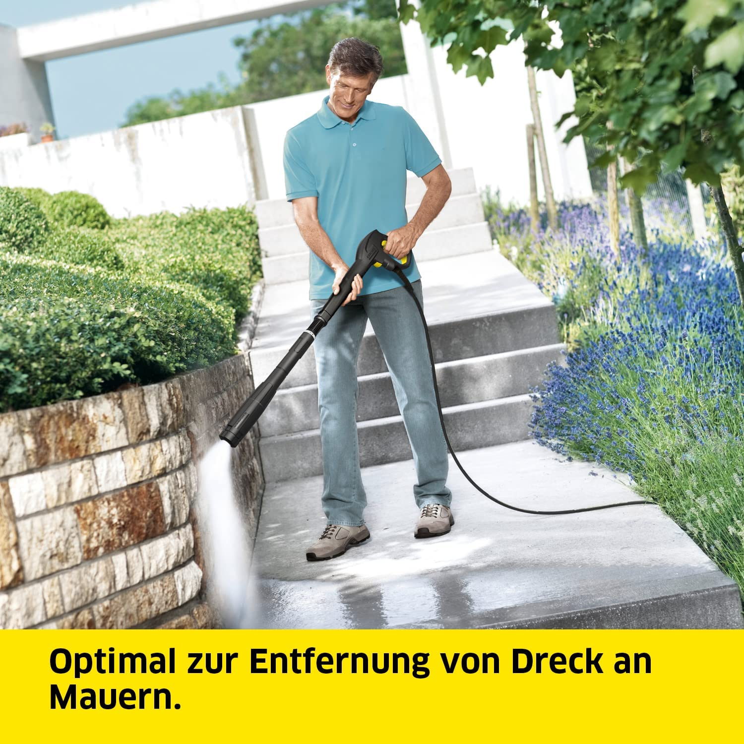 Mann mit Hochdruckreiniger auf Stufen. Stufen, eine Mauer und Pflanzen im Hintergrund. Text: Optimal zur Entfernung von Schmutz.