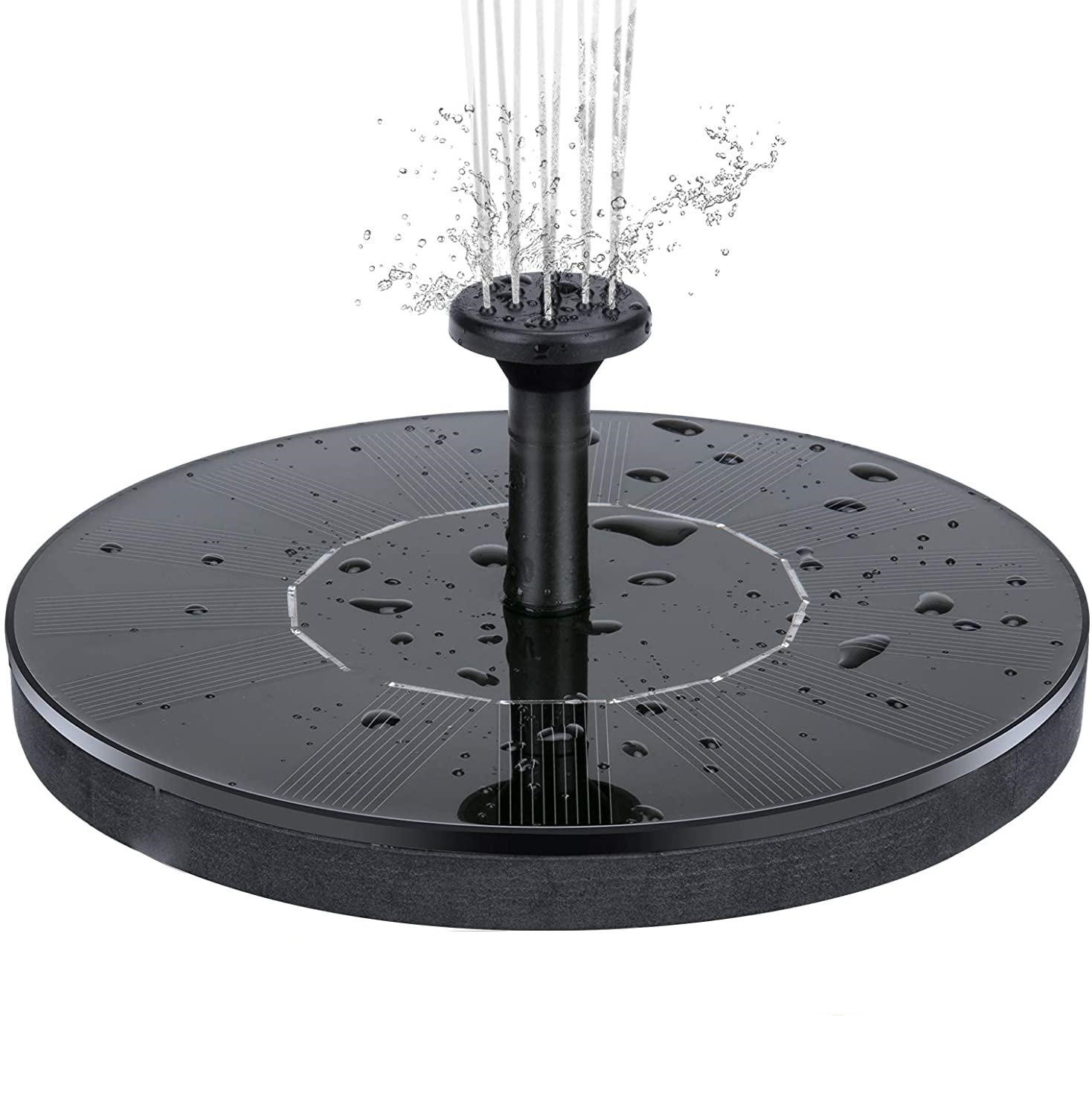 Słoneczna fontanna wodna. Czarna podstawa z wodą rozpryskującą się w górę. Widoczne krople wody.