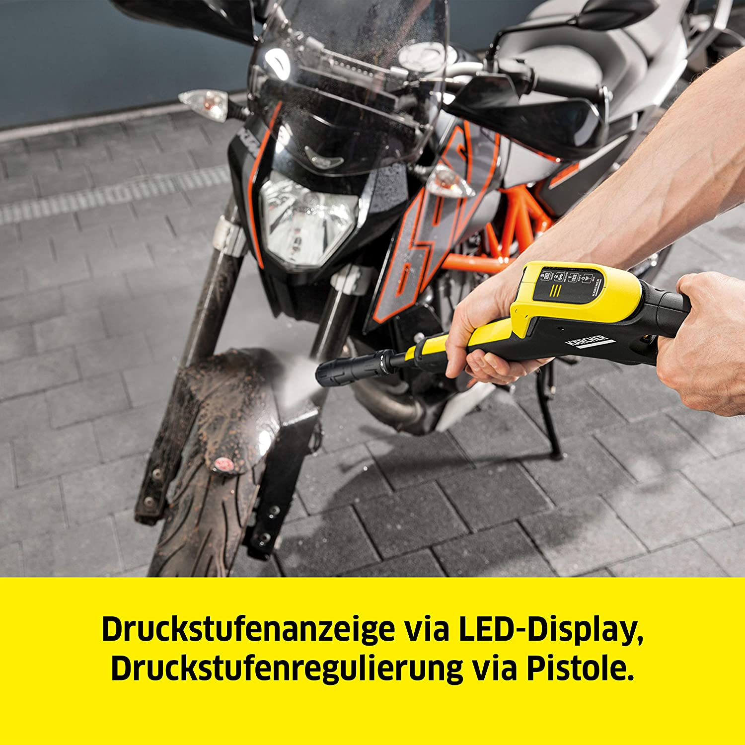 Una persona pulisce una moto con un'idropulitrice. Testo: Visualizzazione del livello di pressione tramite display LED.