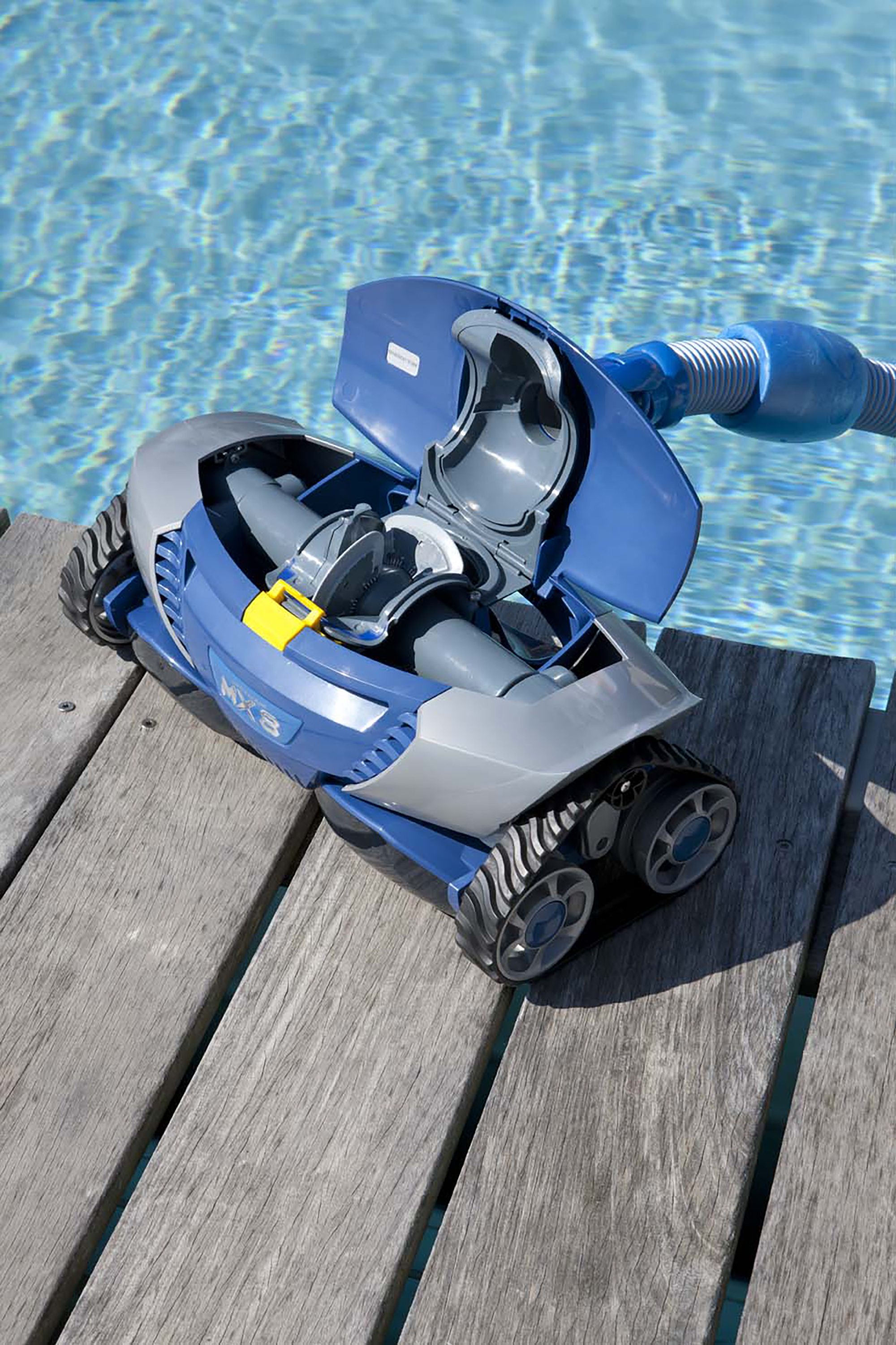 Poolroboter im Pool. Blaue Oberseite geöffnet, mit Schlauchanschluss auf Holzdeck.