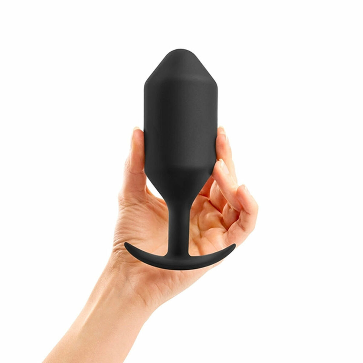 Ein schwarzer Analplug wird vor weißem Hintergrund in einer Hand gehalten.