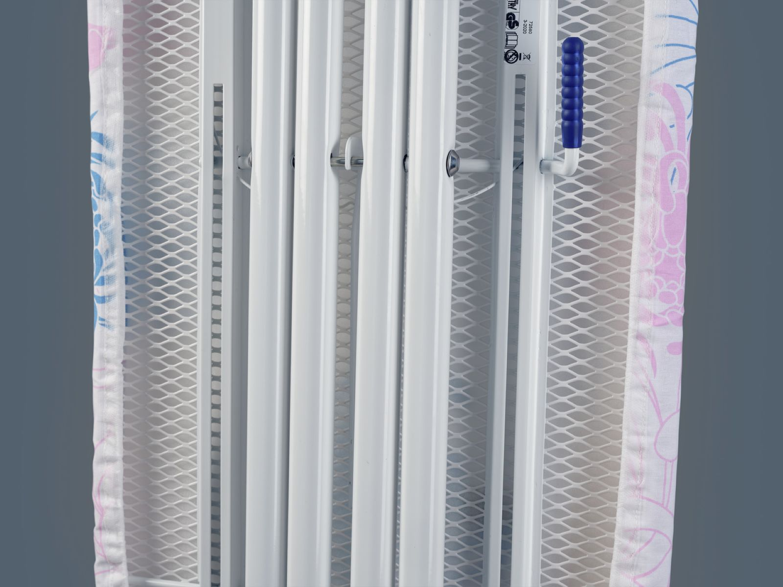 Una tabla de planchar con una funda estampada, mostrando la estructura y el asa azul.