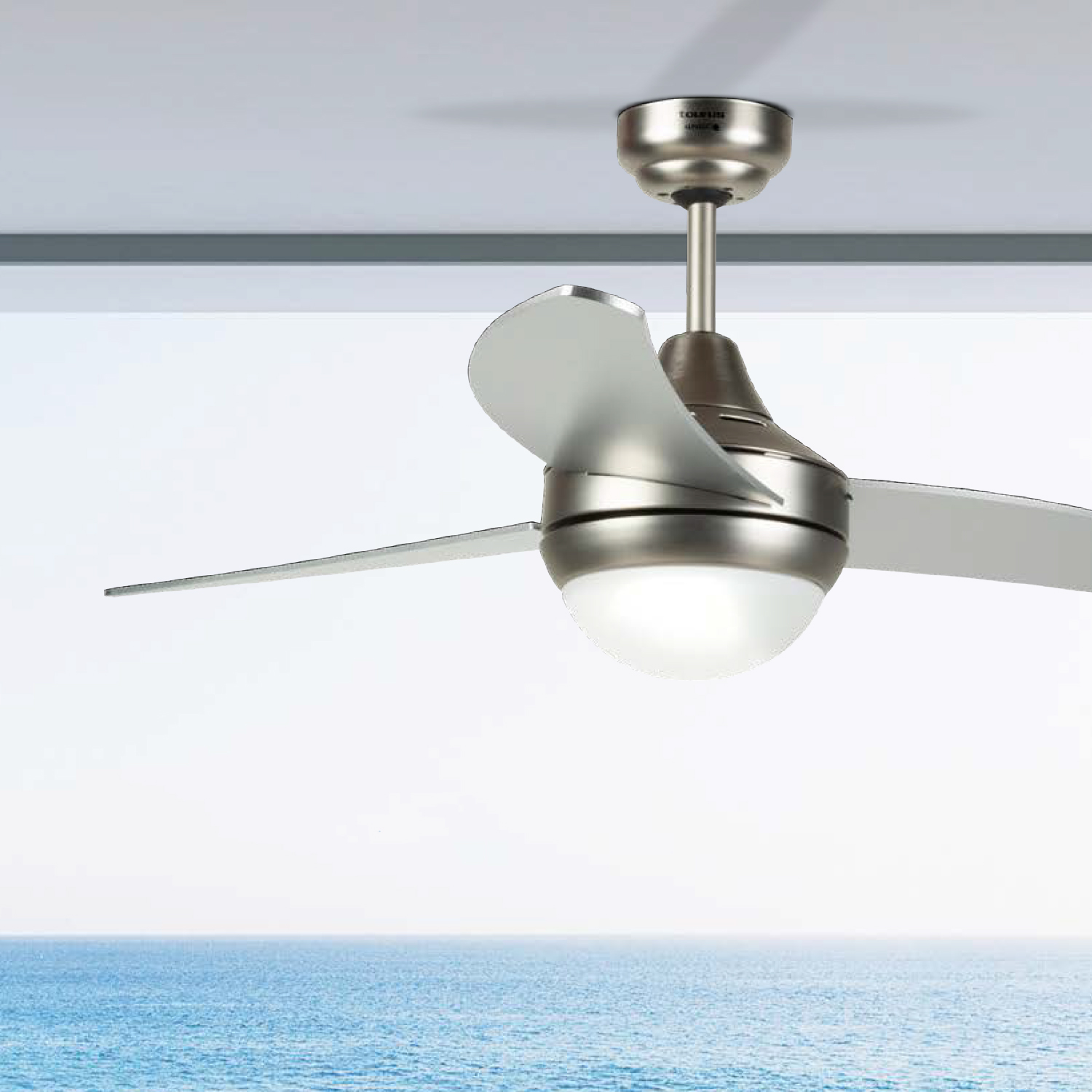 Ventilador de techo plateado con tres aspas, una luz y un fondo de océano azul.
