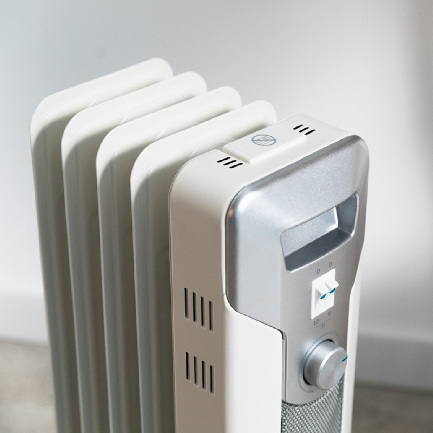 Biały, pionowy kaloryfer ze srebrnym panelem sterowania i pokrętłem z boku.