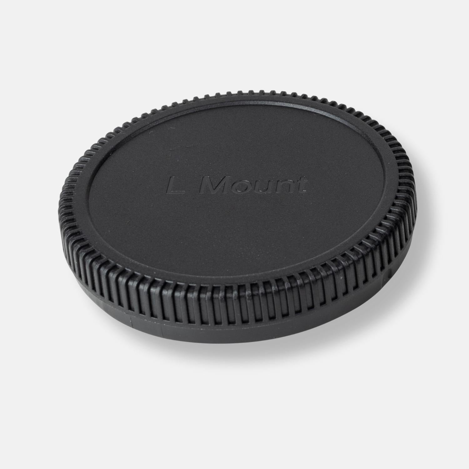Eine schwarze Objektivkappe für eine Kamera. Es hat die Worte L Mount darauf.