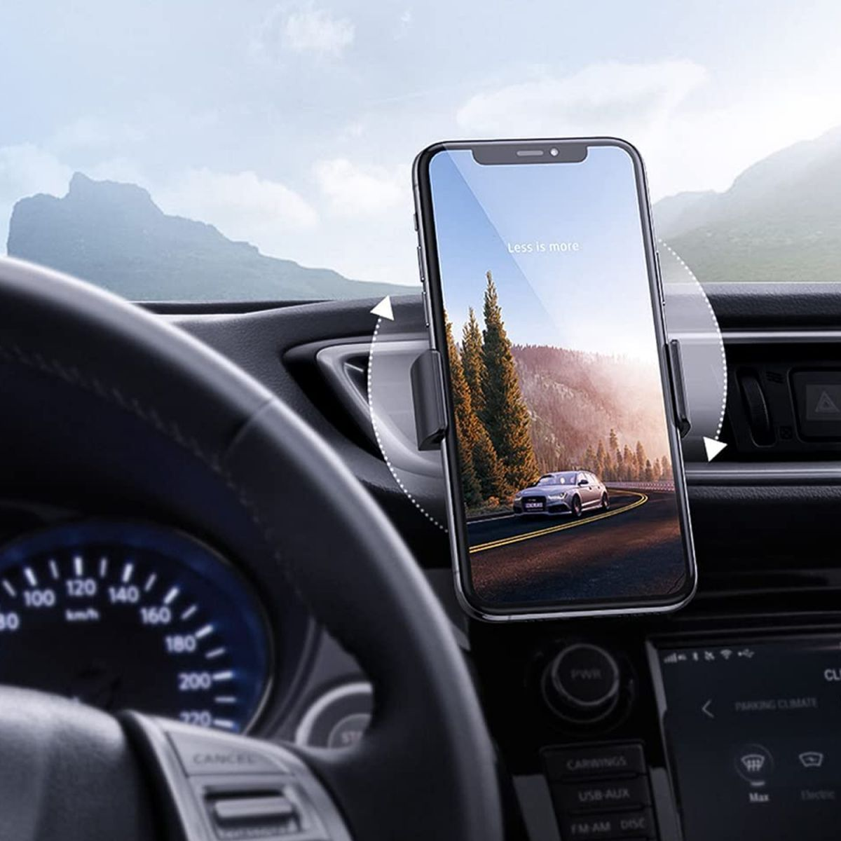 Ein Telefon in einer Autohalterung zeigt eine Straßenszene. Armaturenbrett und Lenkrad sind sichtbar.