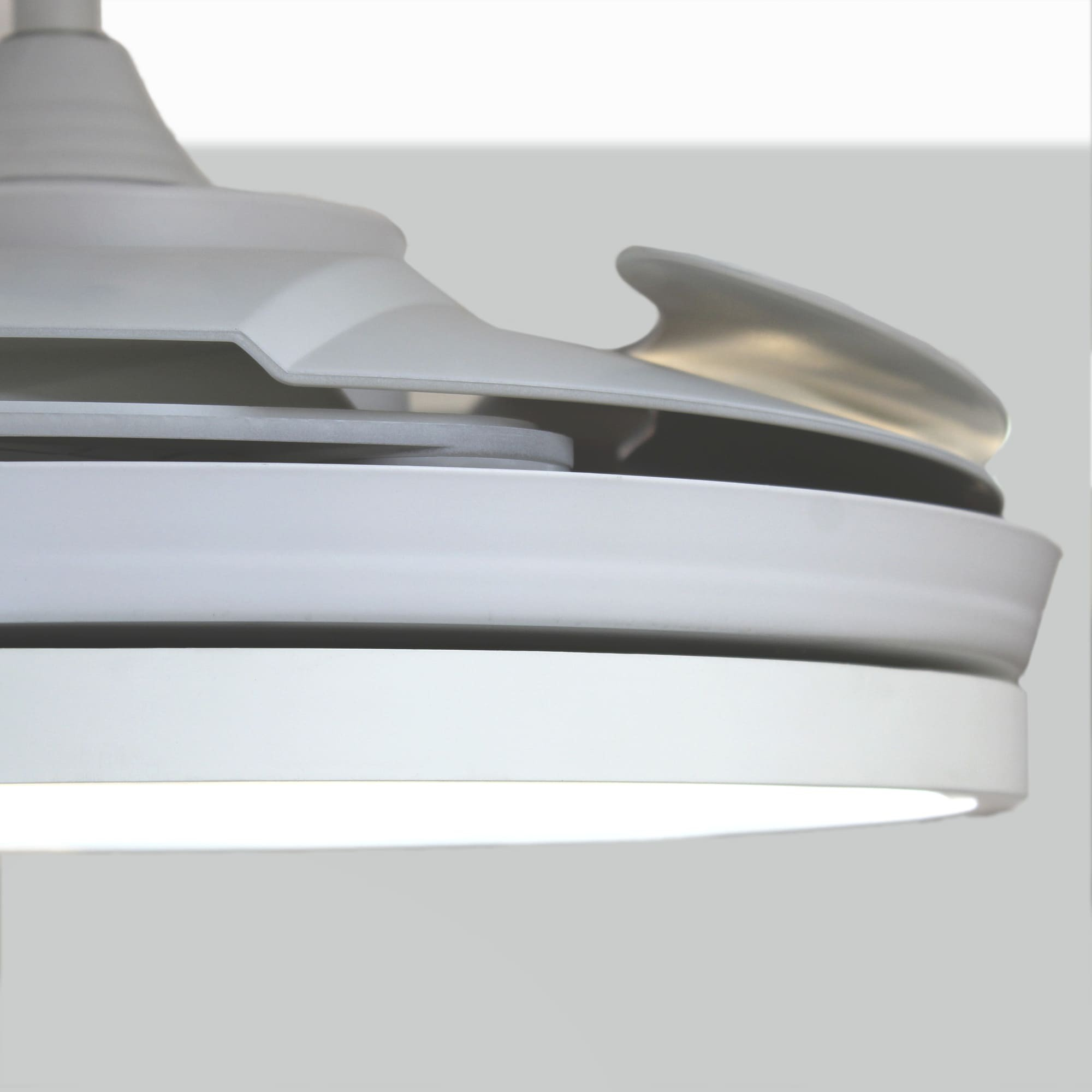 Ventilador de techo blanco, primer plano. Se ven las aspas y la luz. Fondo gris.