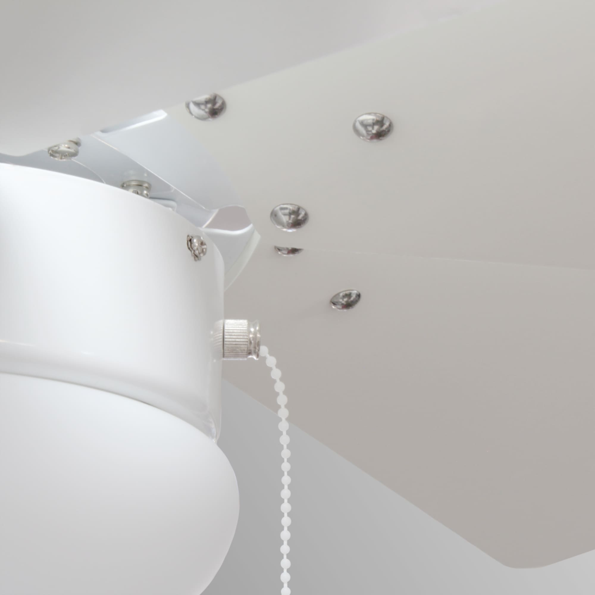 Un primer plano de un ventilador de techo blanco. El ventilador tiene aspas blancas y una base blanca.