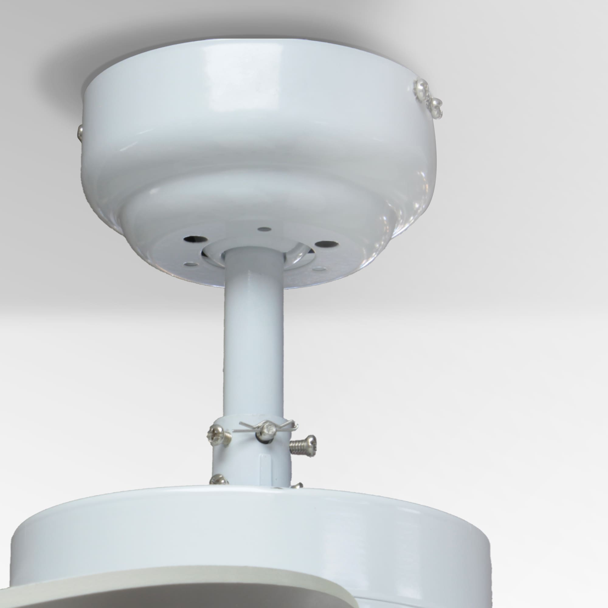 Primer plano del soporte de un ventilador de techo blanco en el techo. Se ven tornillos.