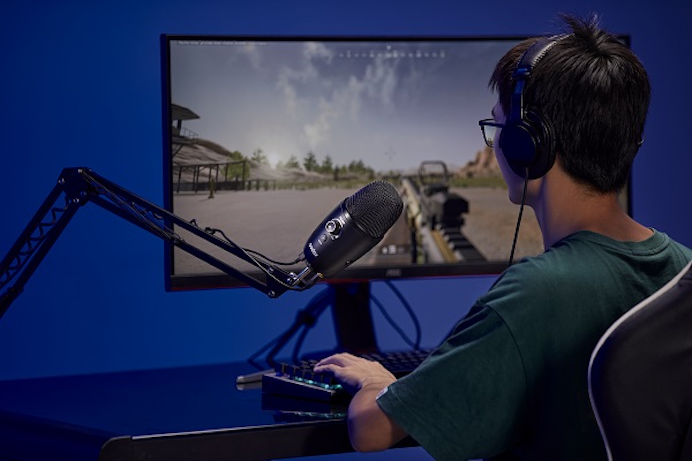 Un joueur portant un casque joue à un jeu sur un PC avec un microphone.