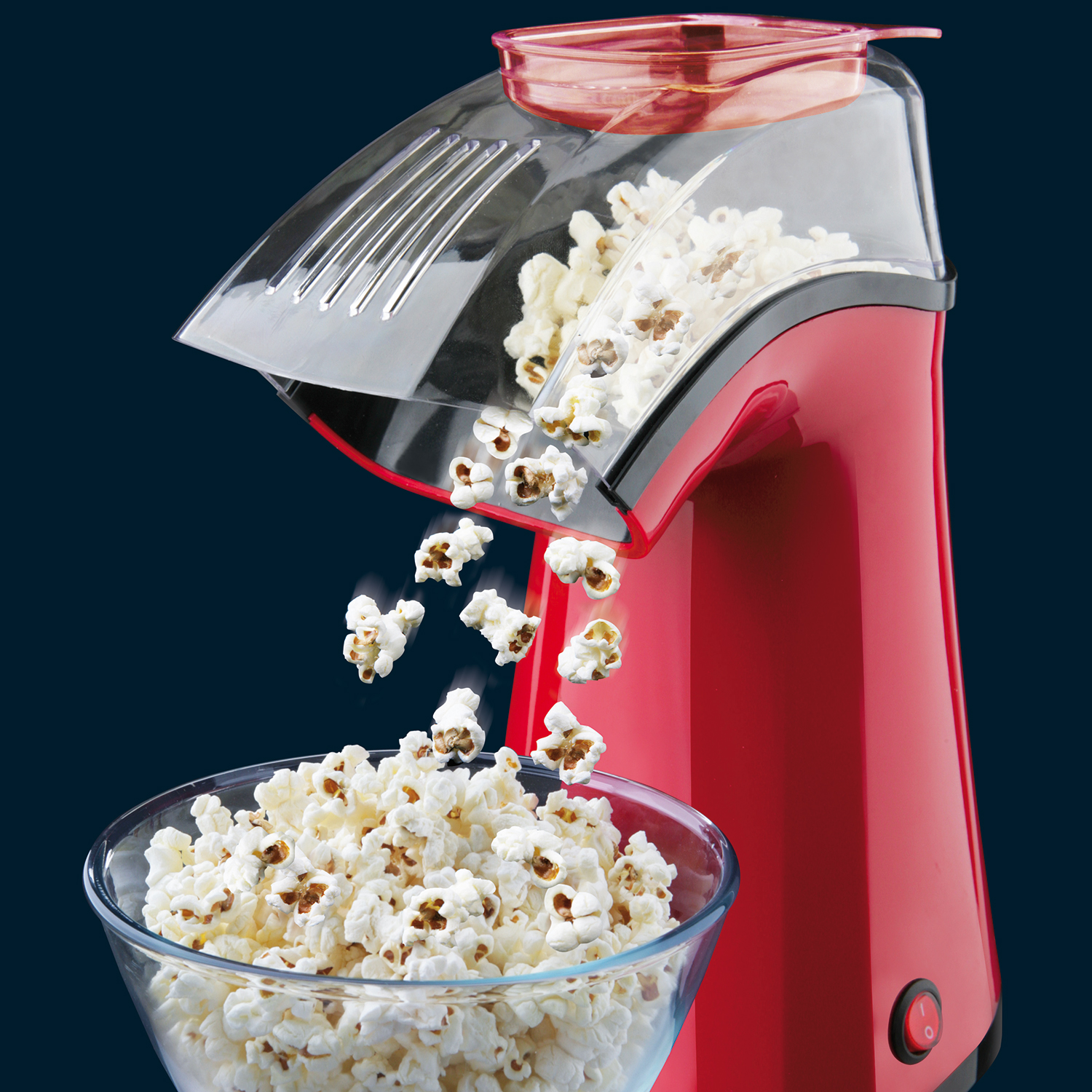 Roter Popcornbereiter, der Popcorn in eine Glasschüssel abgibt.