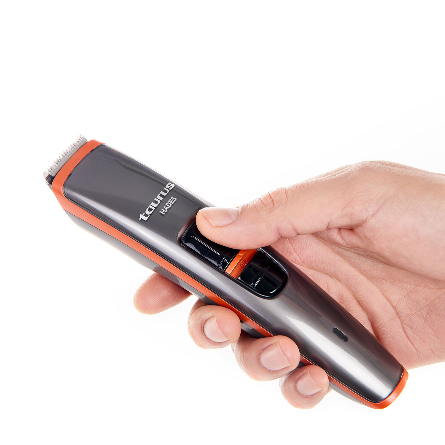 Un cortapelos gris y naranja se sostiene en una mano. El cortapelos tiene la marca 'Taurus Hades'.