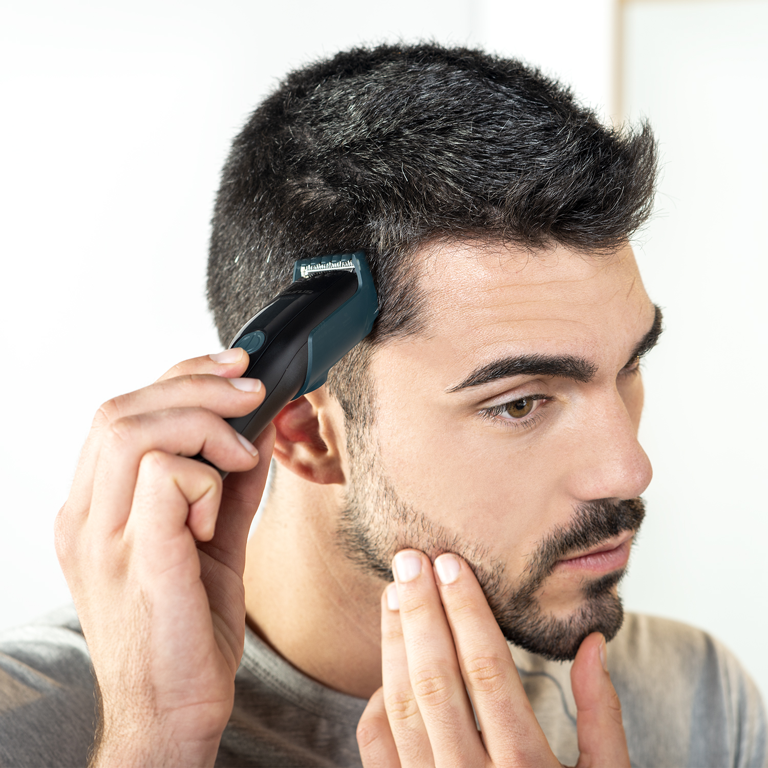 Hombre usando una recortadora de barba, primer plano.
