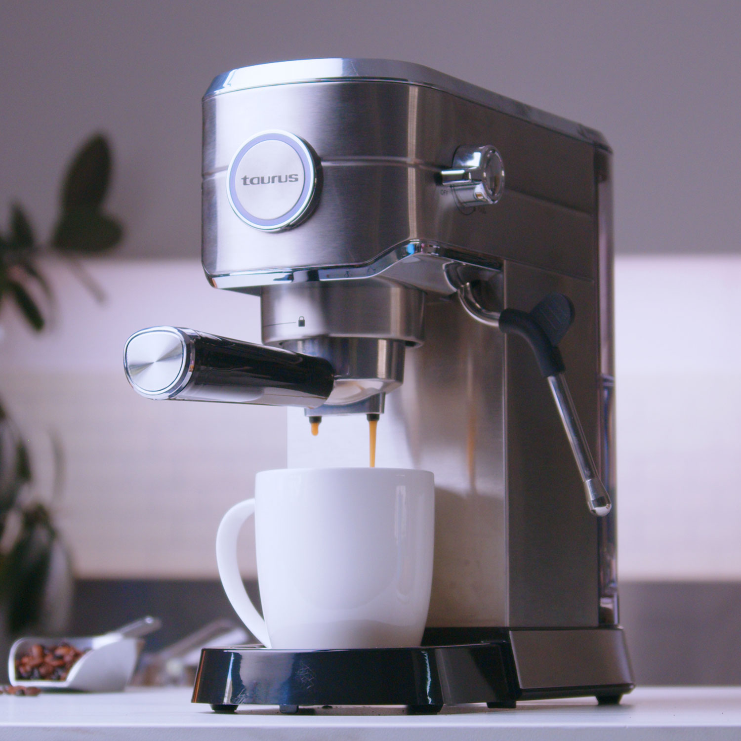 Máquina de espresso de acero inoxidable, vertiendo café en una taza blanca.