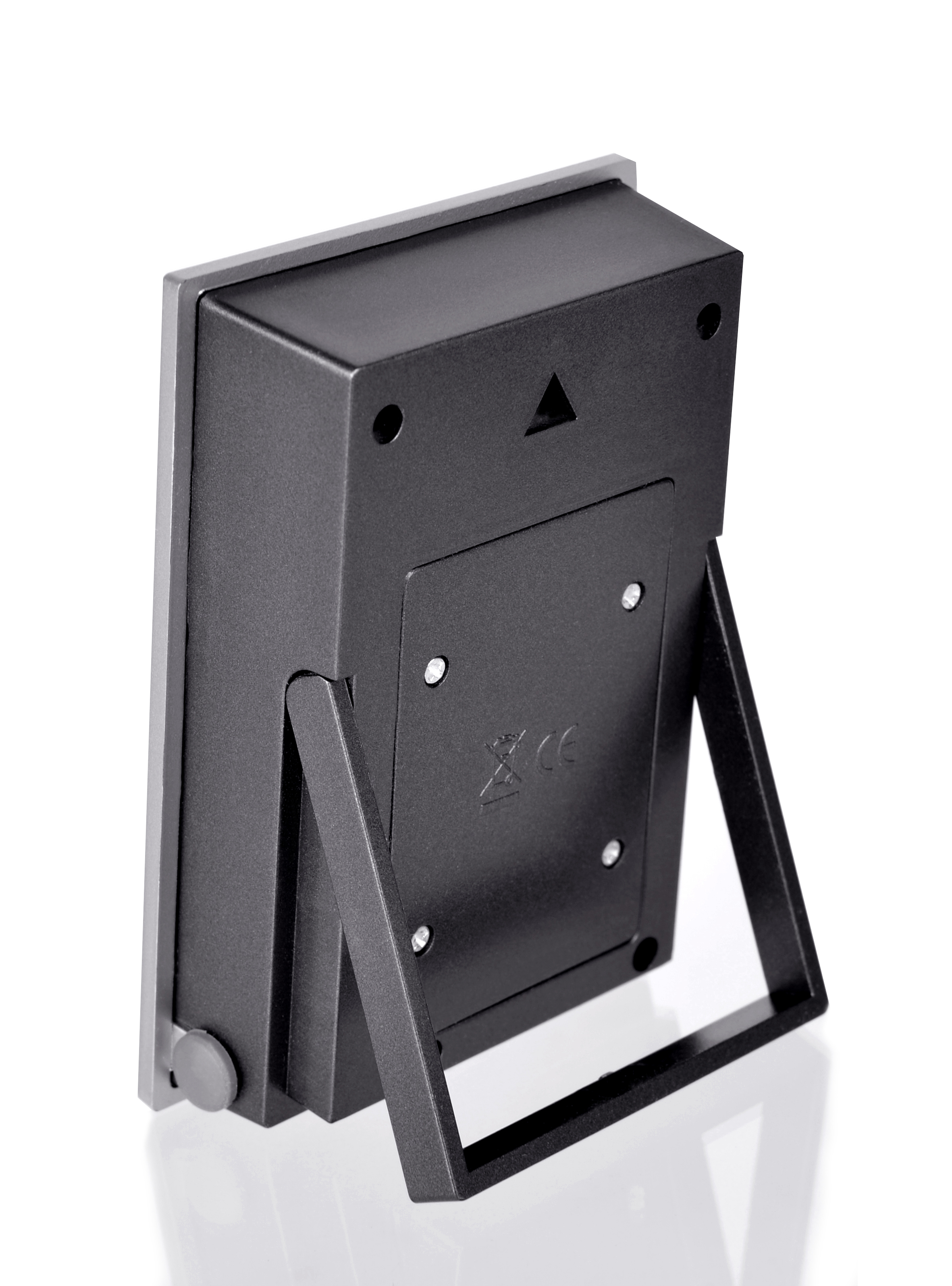 Dispositivo negro con soporte. Vista trasera. Borde gris y un pequeño soporte visible abajo.
