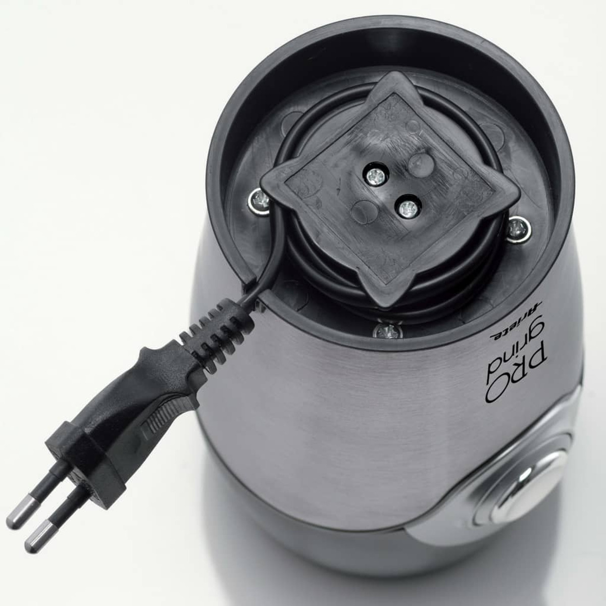 Eine Kaffeemühle hat einen Stecker und ein Kabel. Die Mühle ist silber und schwarz.