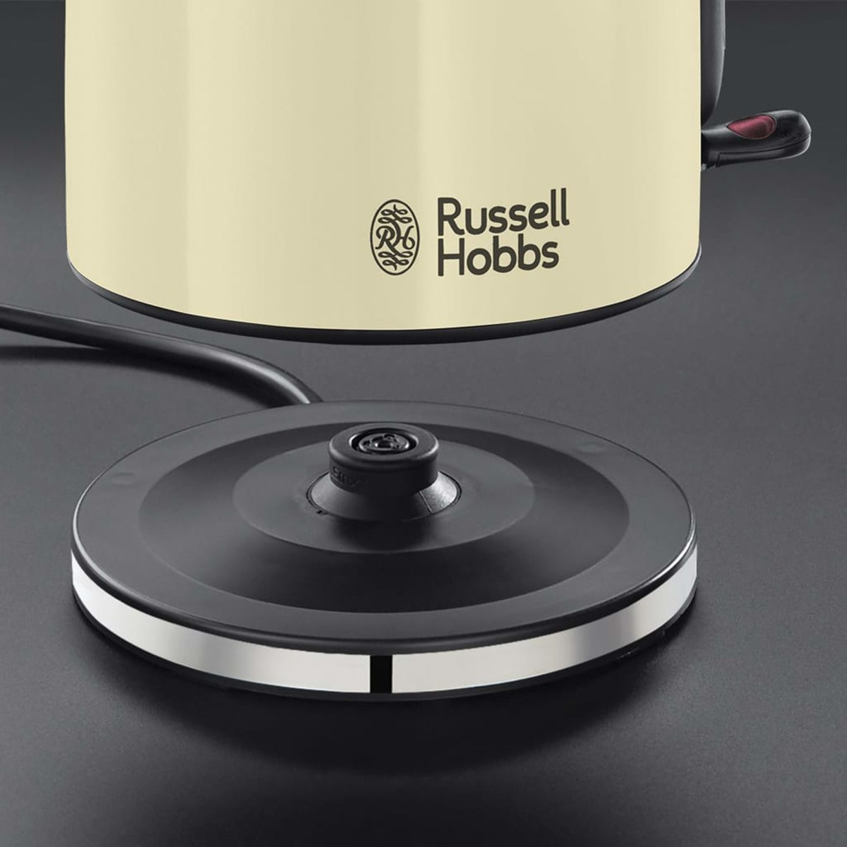 Nahaufnahme eines cremefarbenen Wasserkochers von Russell Hobbs auf schwarzem Sockel.