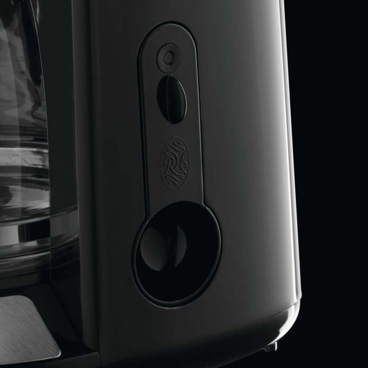 Zbliżenie bocznego panelu czarnego ekspresu do kawy.