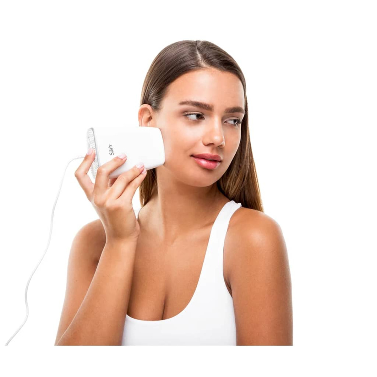 Mujer usando un dispositivo blanco en su rostro. Lleva una camiseta blanca y tiene un tono de piel claro.