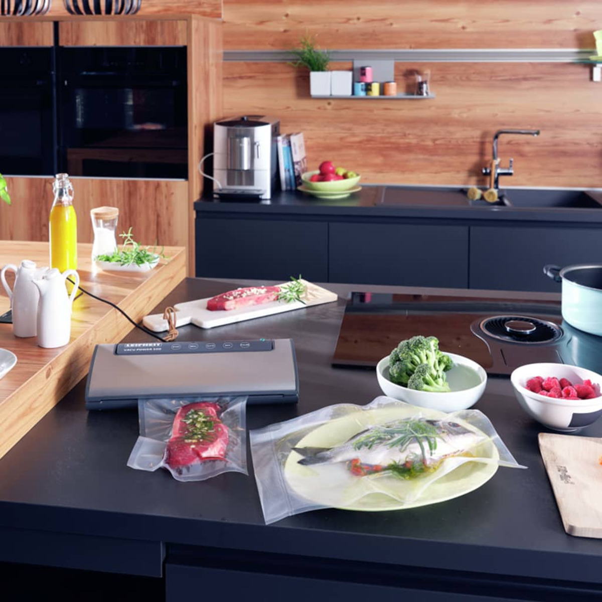 Kuchnia z zgrzewarką próżniową, żywnością w workach i składnikami na blacie.