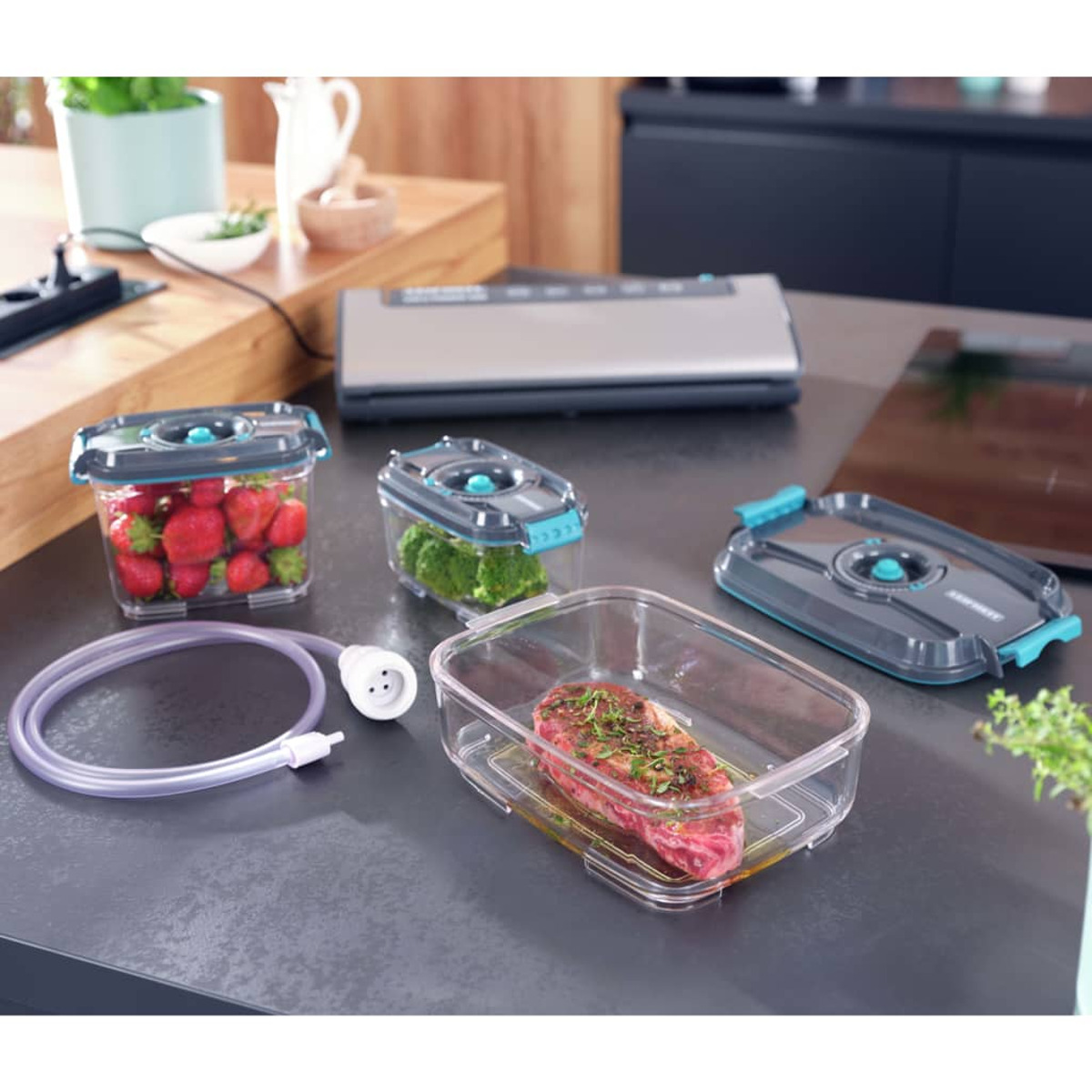 Contenedores con fresas, brócoli y filete con sellador al vacío y manguera.
