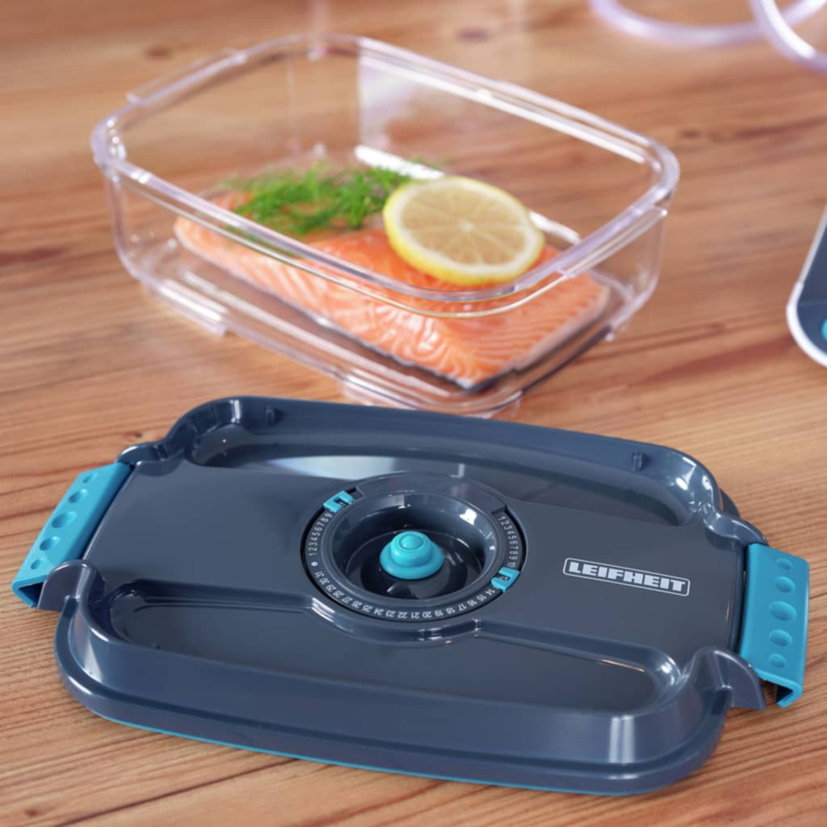 Contenedor de almacenamiento con salmón, limón y eneldo. Una tapa está cerca del contenedor.