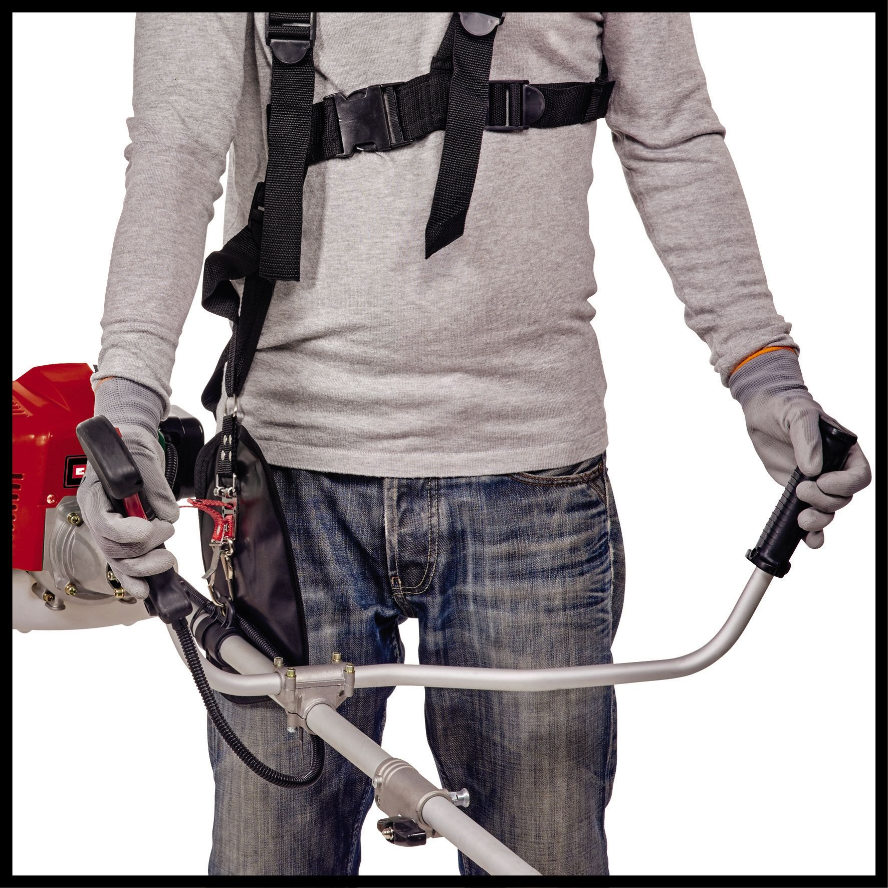 Person mit grauem Shirt, Jeans und Handschuhen, hält eine rote und silberne Motorsense auf weißem Grund.