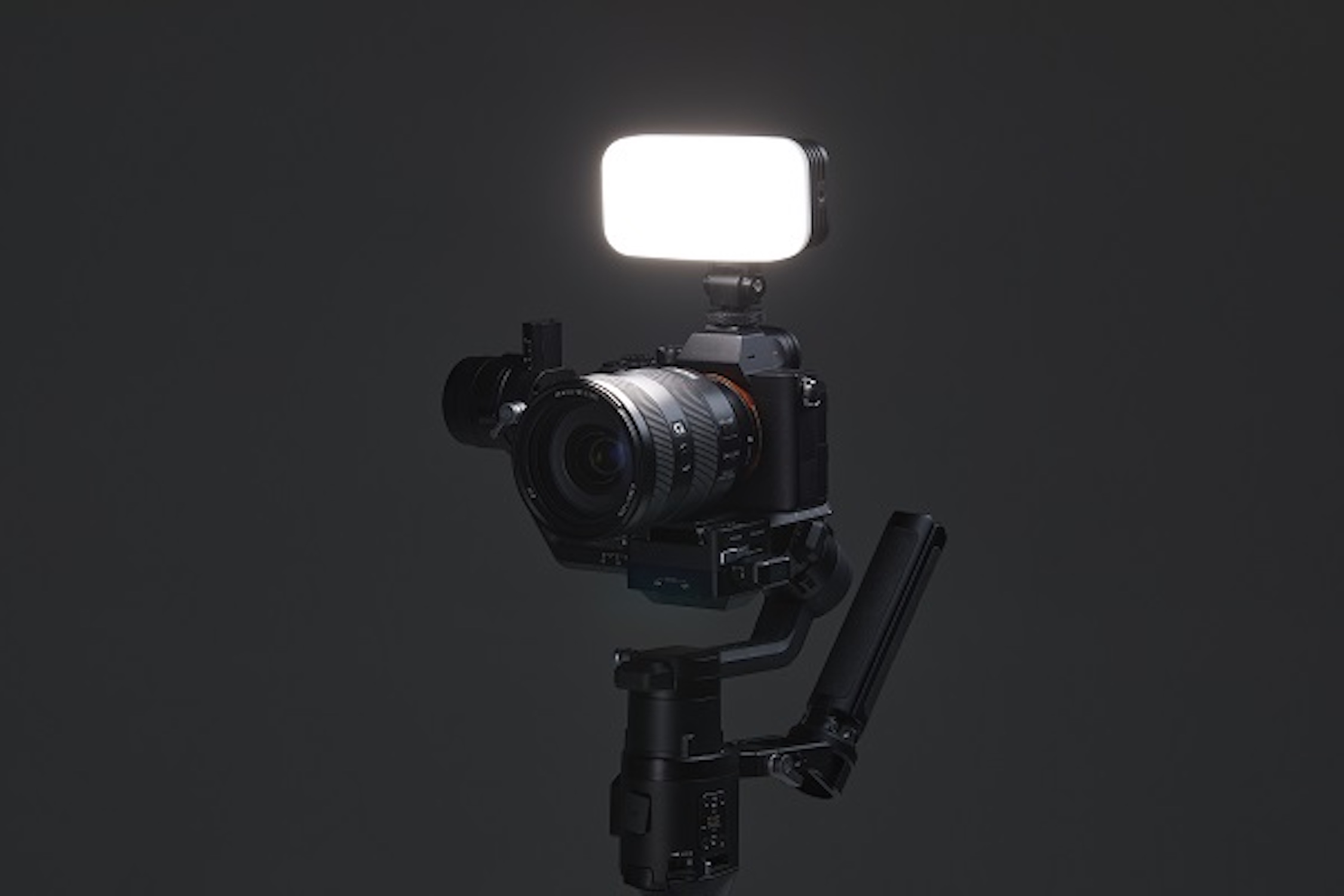 Kamera auf Gimbal montiert, mit Licht oben, dunkler Hintergrund.