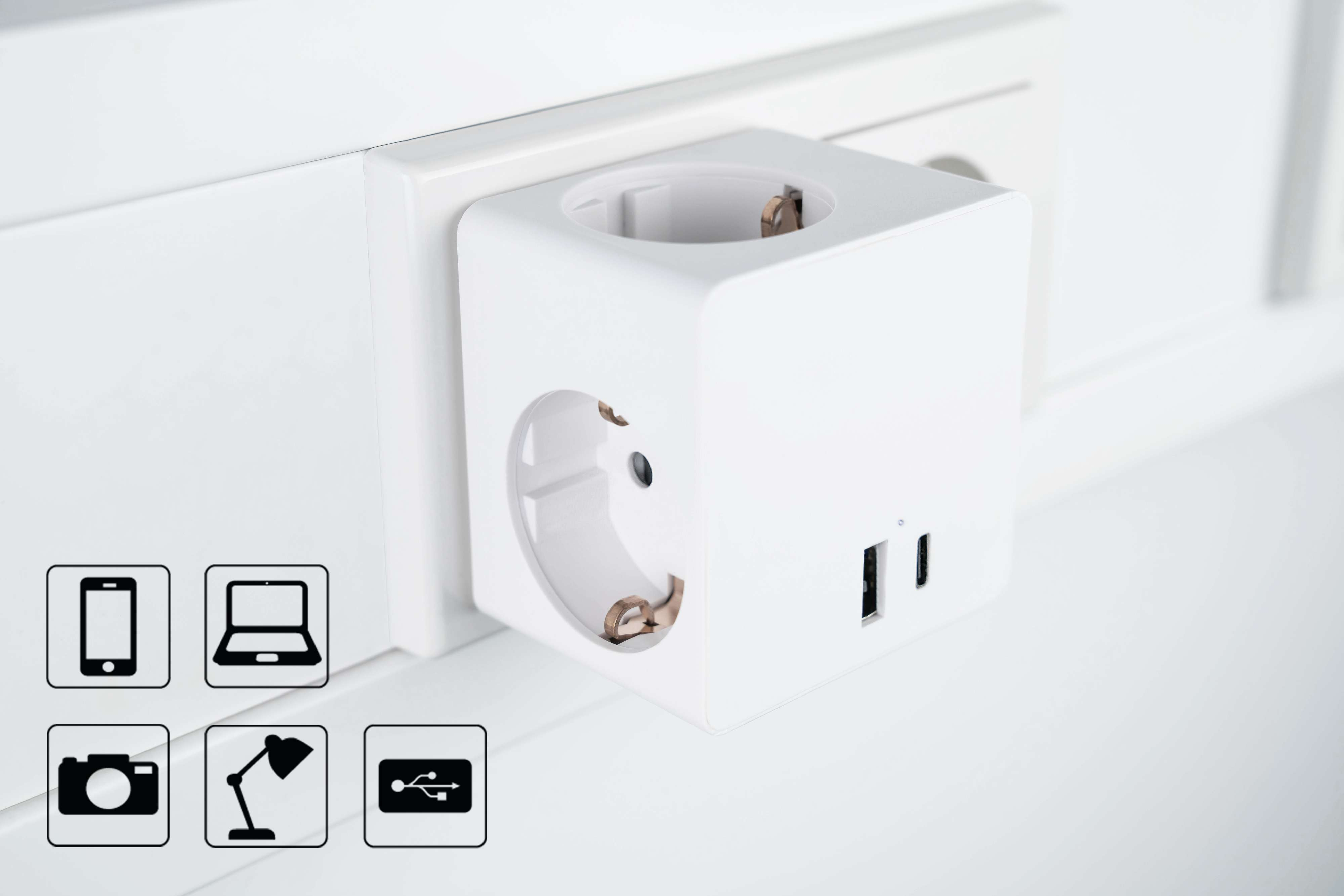 Weißer Würfeladapter mit mehreren Steckdosen und USB-Anschlüssen. Symbole für Geräte wie Handys und Laptops sind angezeigt.