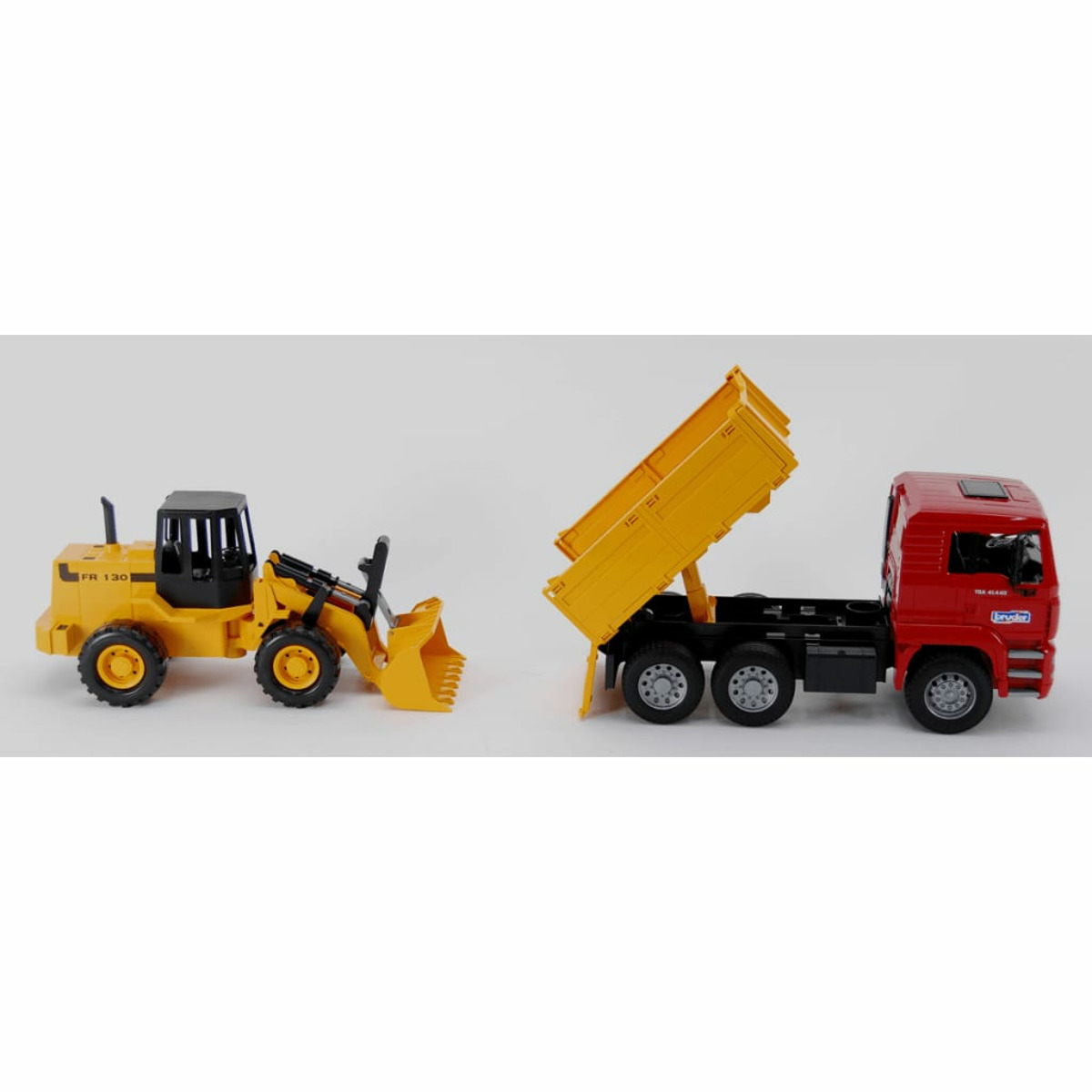 Żółta ładowarka czołowa i czerwona ciężarówka z podniesioną skrzynią, białe tło.