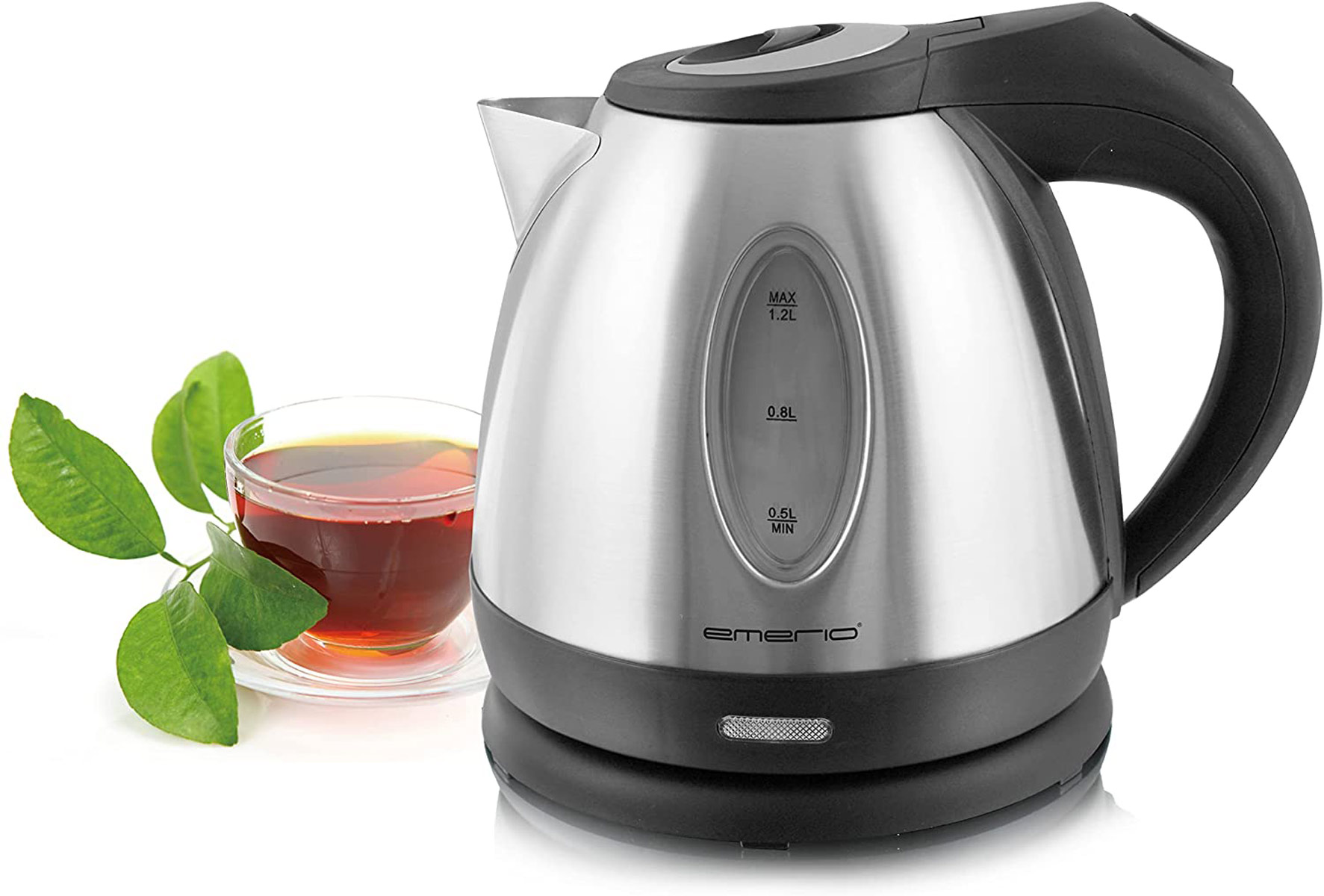 Una tetera de acero inoxidable con un vaso de té y hojas delante.