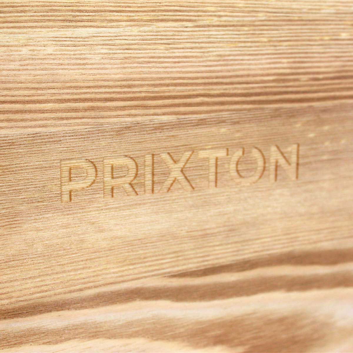 Zbliżenie drewna z wygrawerowanym słowem 'PRIXTON'.