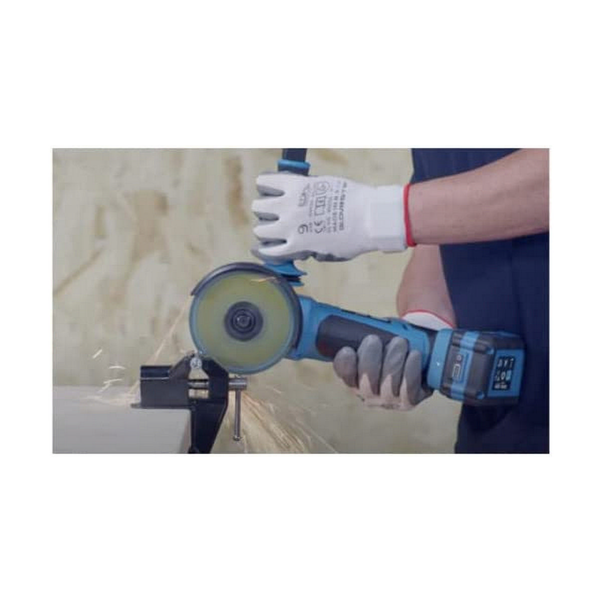 Persona usando una amoladora angular en metal, saltan chispas, lleva guantes.