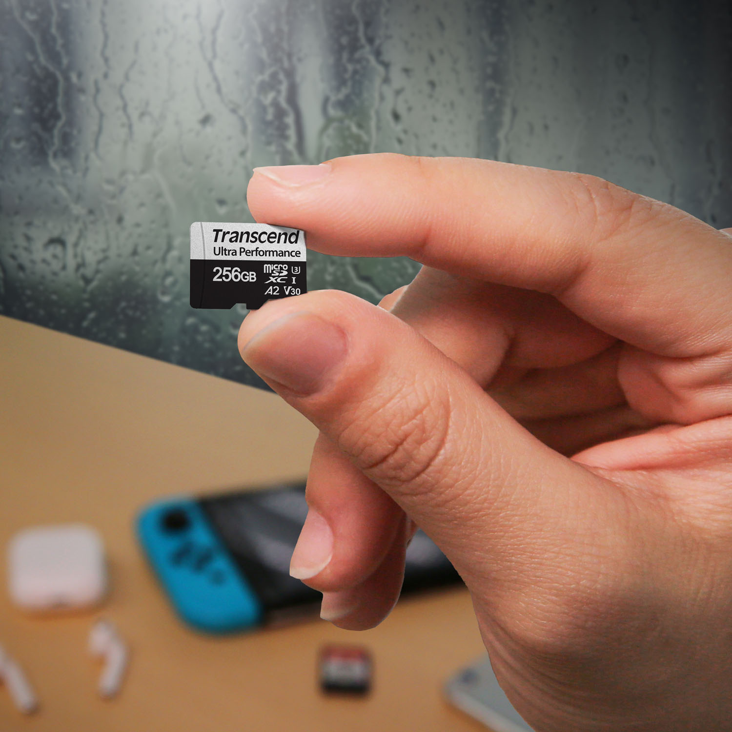 Eine Hand hält eine kleine schwarze und silberne Micro-SD-Karte. Die Karte ist mit 256 GB und anderen Spezifikationen beschriftet.