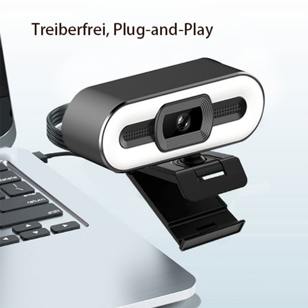 Webcam auf einem Laptop. Die Webcam ist schwarz-weiß mit einem weißen Lichtring. Der Laptop ist geöffnet.