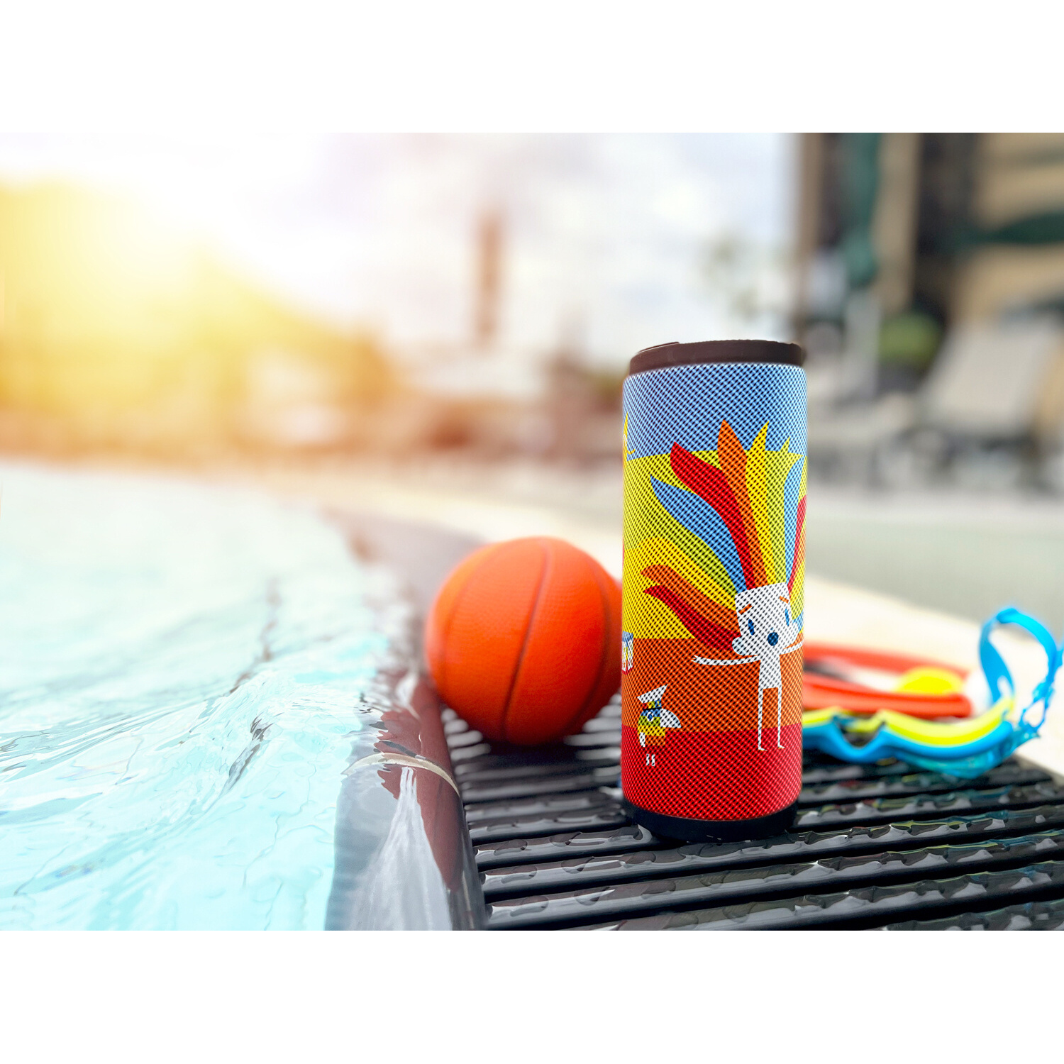 Lautsprecher neben einem Pool mit Basketball und Brille. Sonniger Tag.