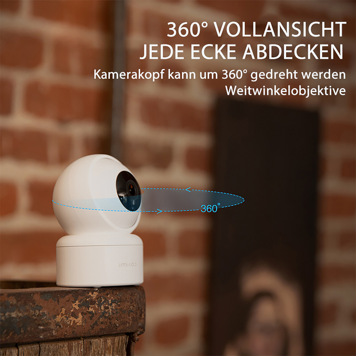 Weiße Überwachungskamera. Die Kamera kann sich um 360 Grad drehen. Text auf Deutsch beschreibt die Funktionen.