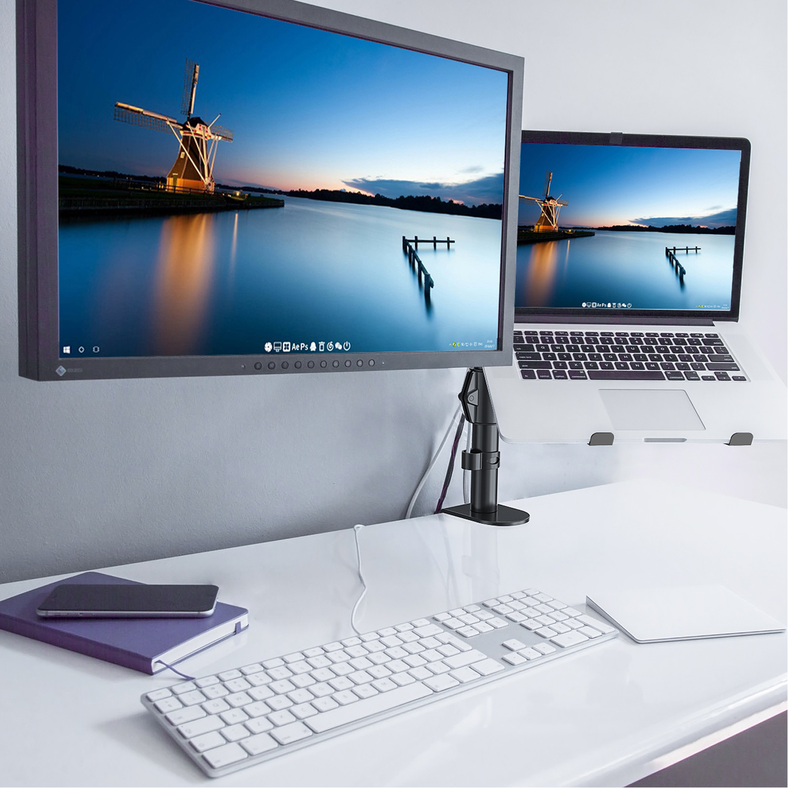 Schreibtisch-Setup mit Monitor, Laptop, Tastatur und Zubehör. Landschaft auf Bildschirmen.