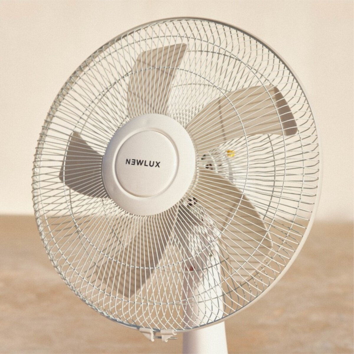 Ventilador blanco con tres aspas. La marca es NEWLUX.