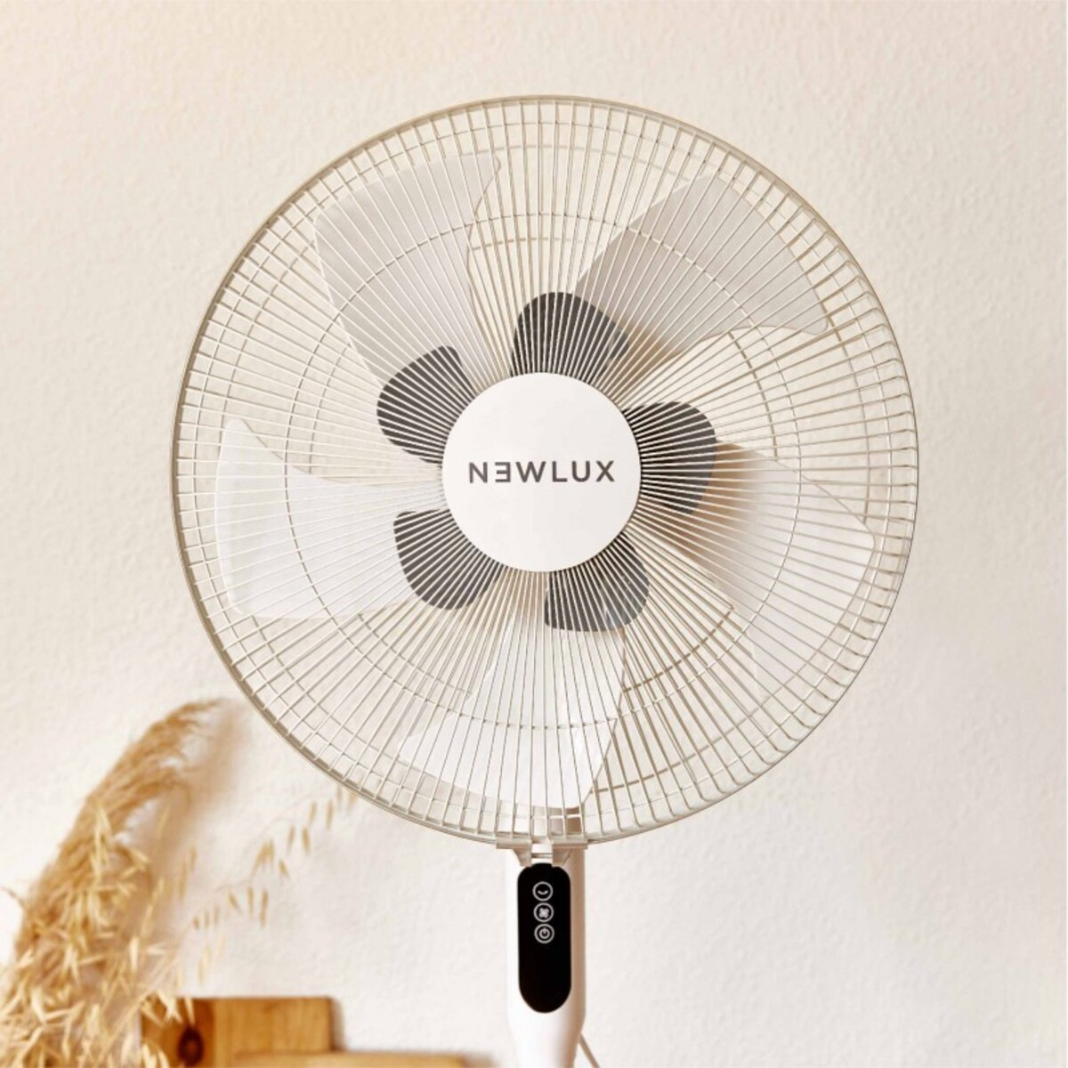 Un ventilador de pie blanco con el logo Newlux, contra una pared clara.