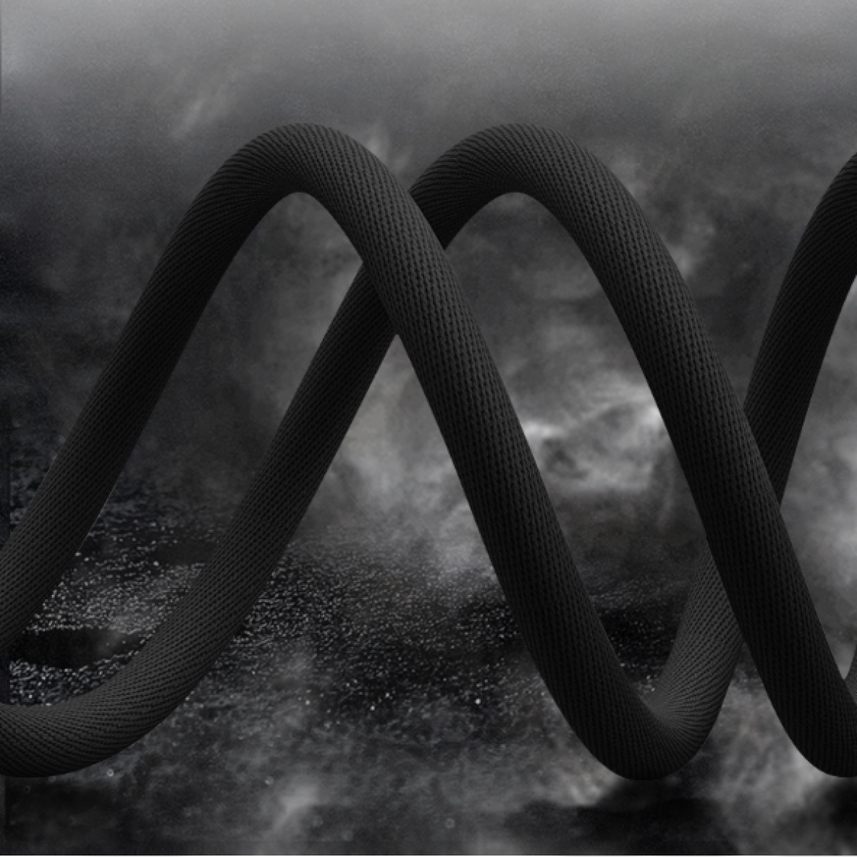 Czarny pleciony kabel w spirali. Tło to rozmyty gradient ciemnych odcieni.