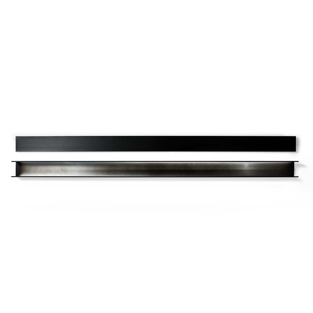 Zwei Metallstangen, eine schwarz, eine silberfarben, liegen horizontal auf weißem Untergrund.