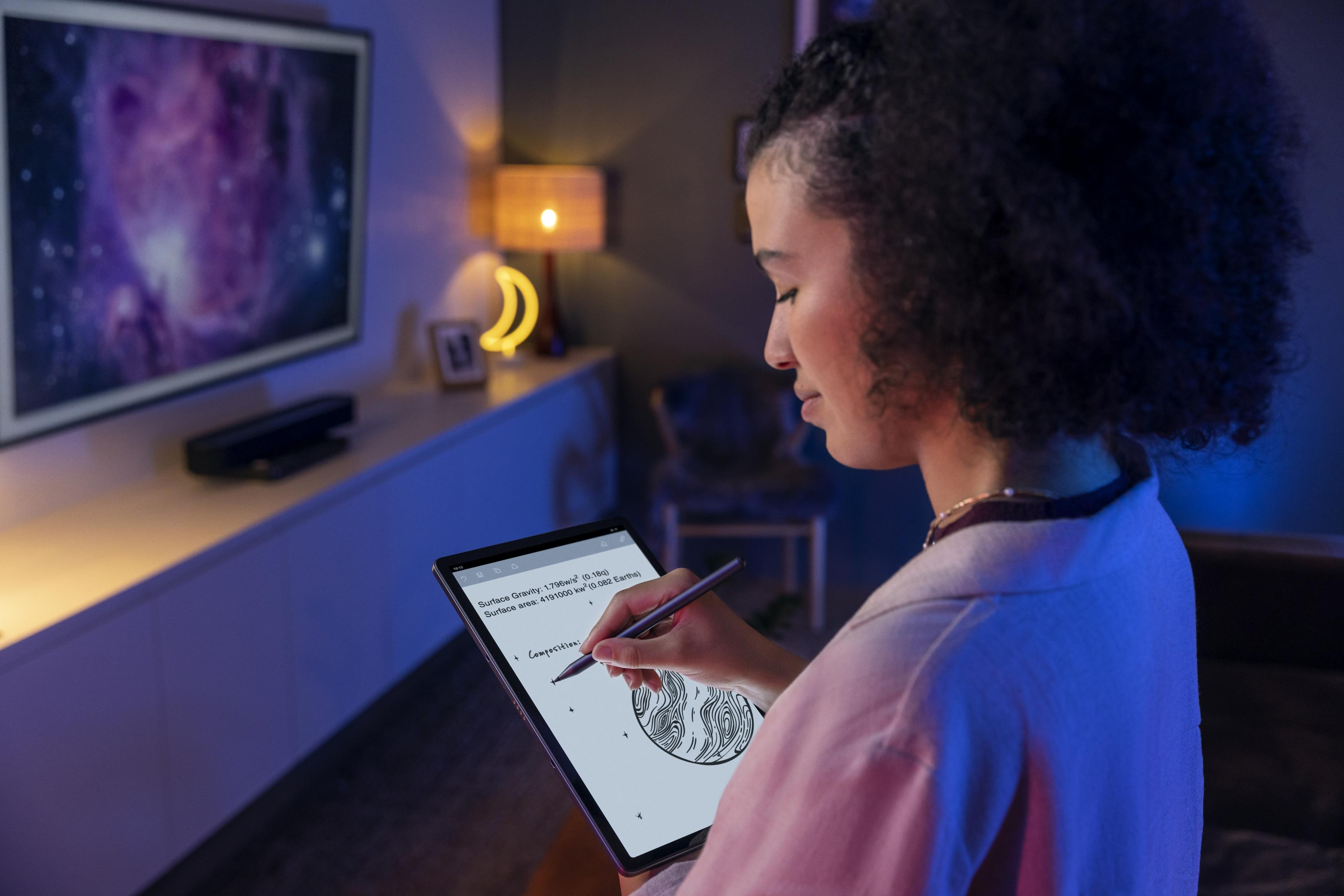 Frau benutzt ein Tablet mit Stift in einem modernen Wohnzimmer.