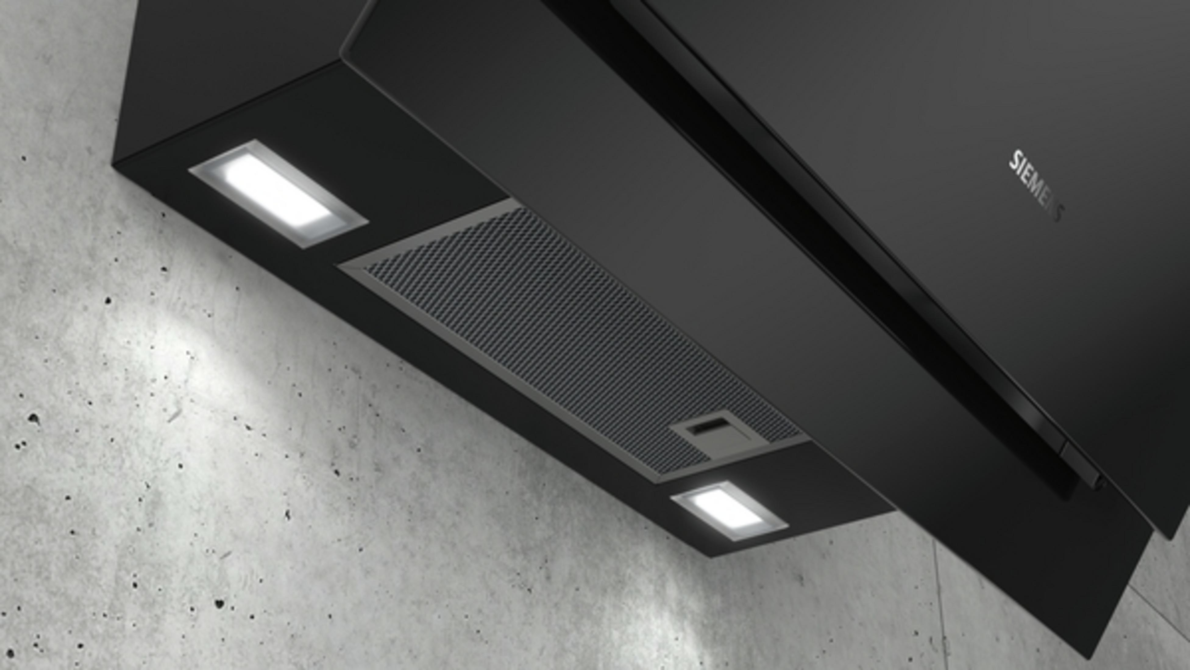 Black range hood with two lights, mounted on a concrete wall. Siemens logo visible.