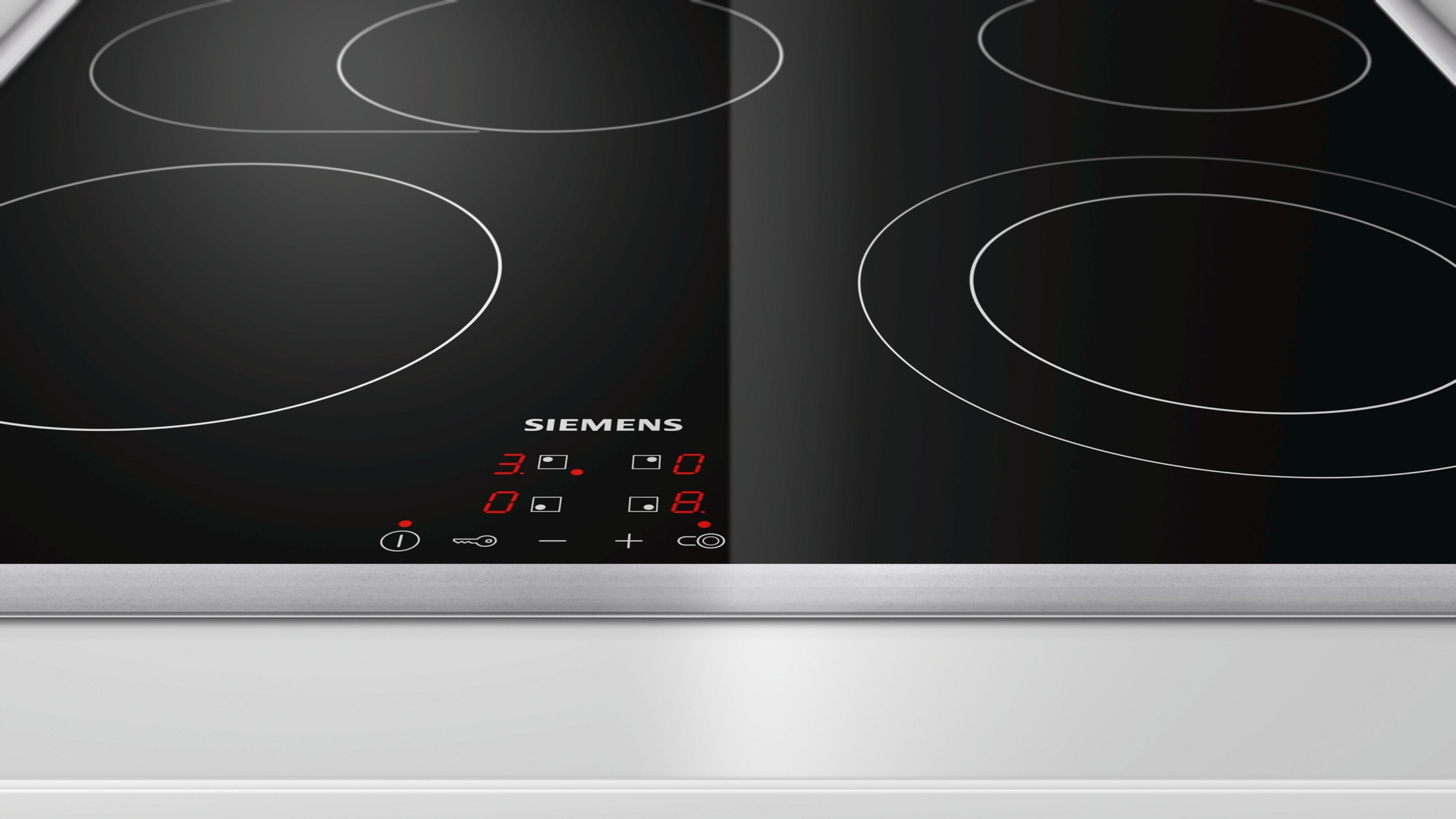 Zbliżenie czarnej płyty indukcyjnej Siemens z czerwono podświetlanymi numerami. Powierzchnia jest czarna.