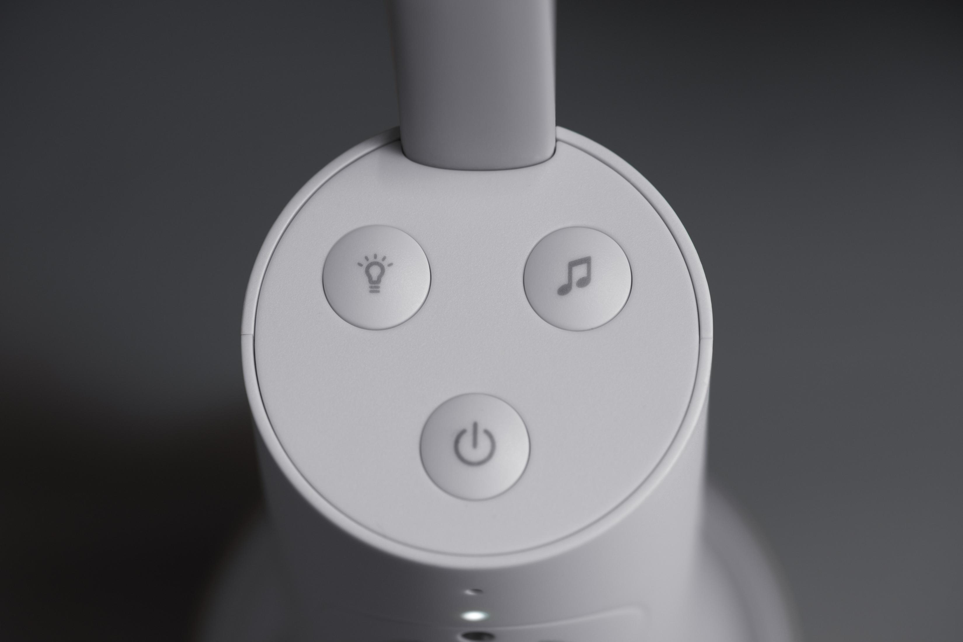 Testa di lampada bianca con tre pulsanti: luce, nota musicale e simbolo di accensione.