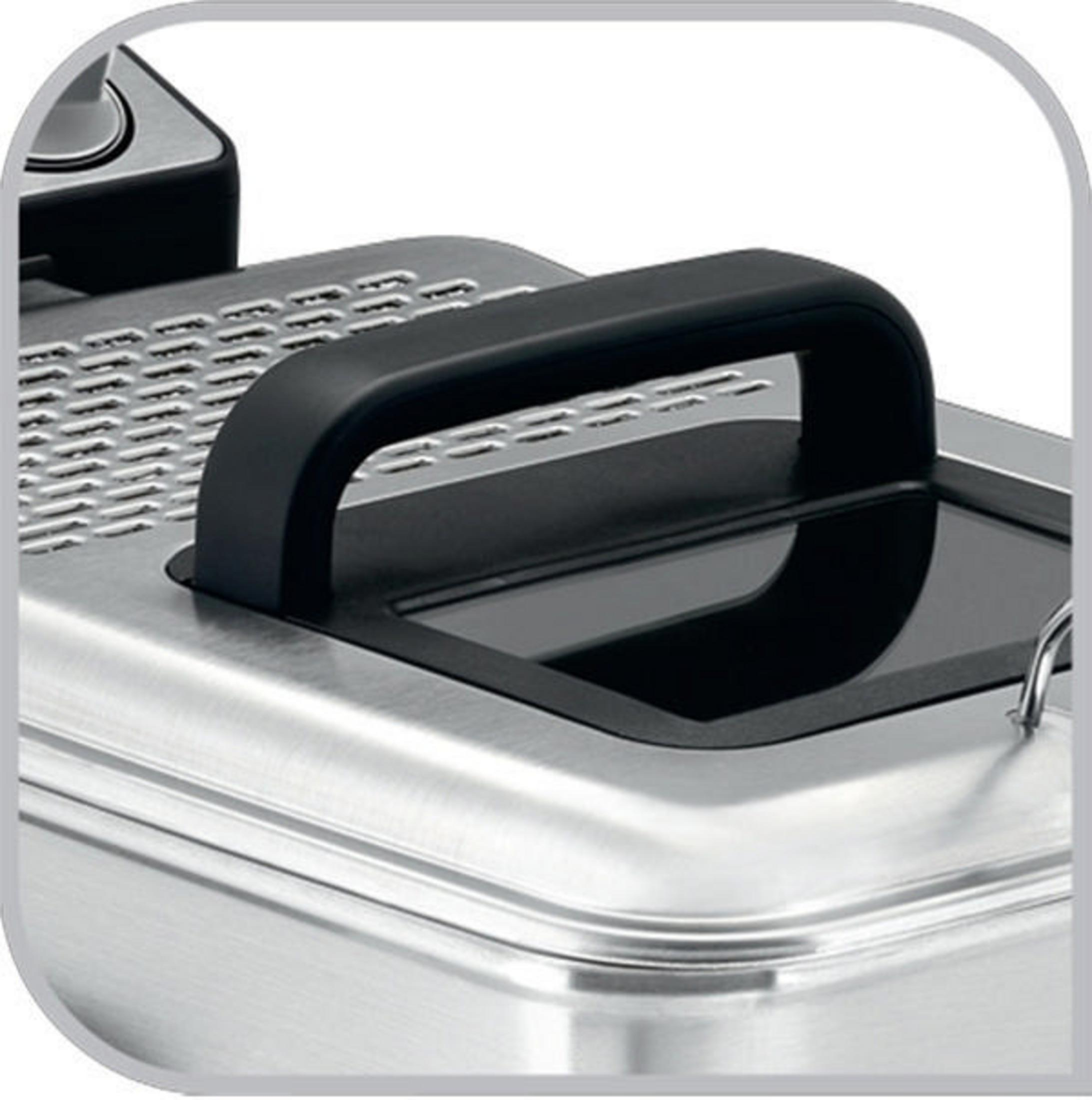 Zbliżenie frytownicy ze stali nierdzewnej. Ma czarny uchwyt i pokrywę.